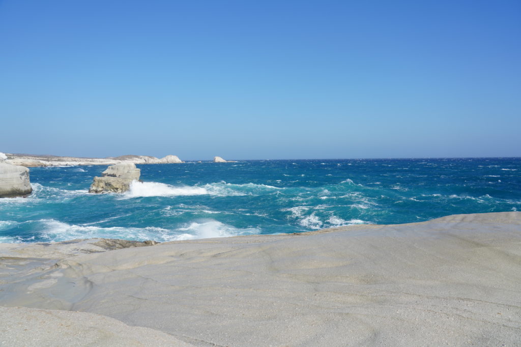 サラキニコビーチ 打ち寄せる青い波と眩い石灰岩の壁に圧倒される最高の景色 ミロス島マンドラキア Trieat